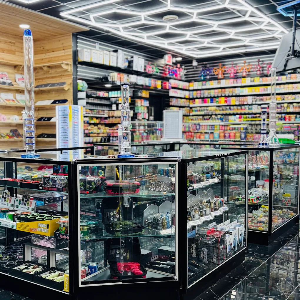 Inside EZ Smoke House Hampton VA — modern interior with glass display cases, hookahs and bongs under hex lighting